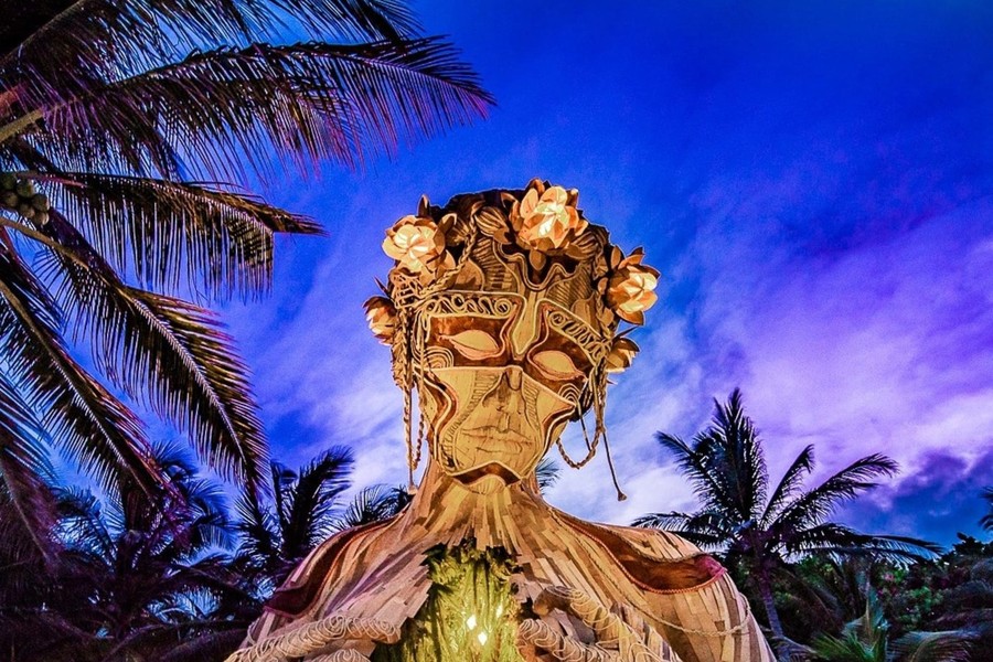 Giant wooden sculpture on the beach in Tulum at dusk
